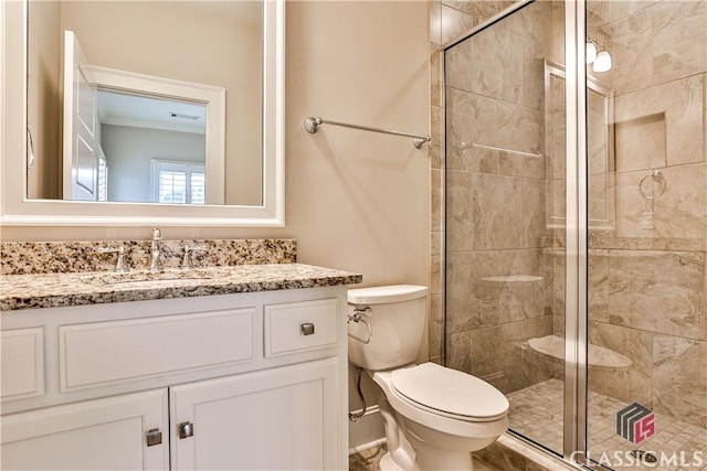 bathroom featuring vanity, an enclosed shower, and toilet