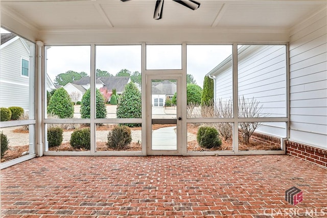 unfurnished sunroom with ceiling fan