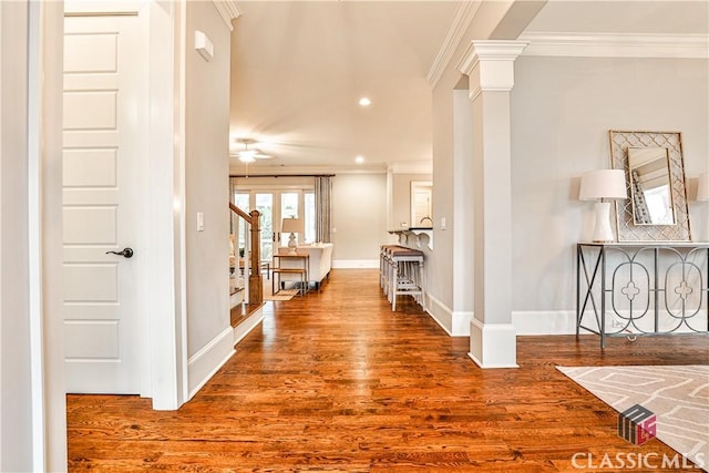 hallway featuring ornate columns, crown molding, and hardwood / wood-style floors