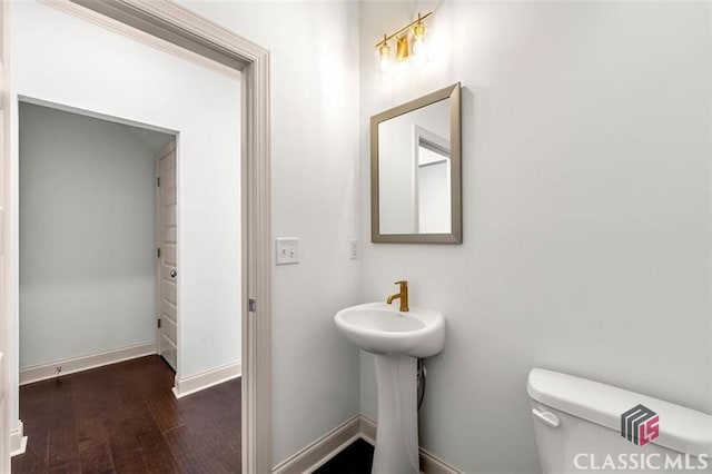 bathroom featuring wood-type flooring and toilet