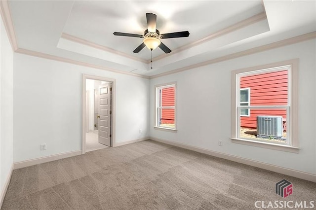 unfurnished bedroom with ceiling fan, multiple windows, crown molding, and a raised ceiling