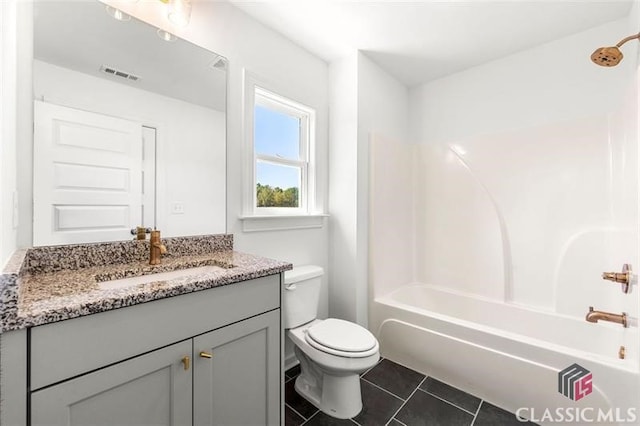 full bathroom featuring toilet, vanity, tile patterned floors, and bathing tub / shower combination