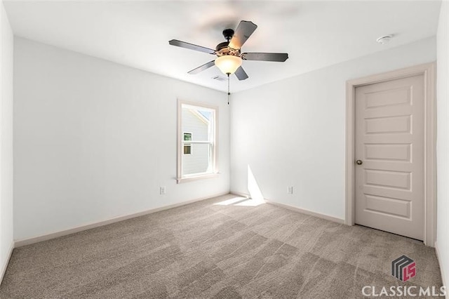 carpeted spare room featuring ceiling fan