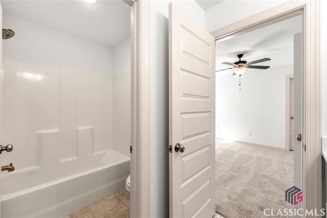 bathroom featuring ceiling fan, toilet, and shower / washtub combination