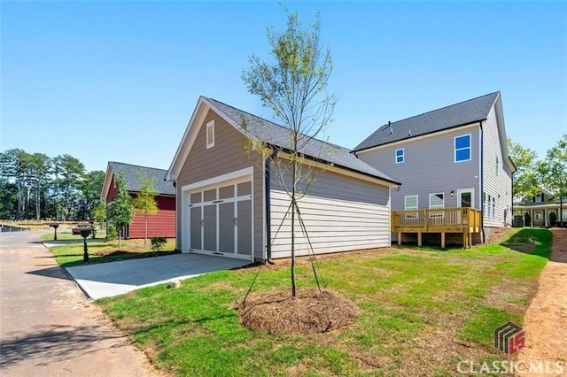 view of home's exterior featuring a garage, a wooden deck, and a yard