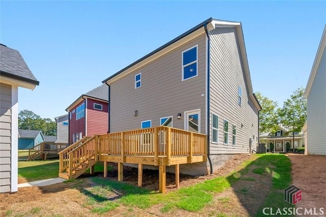 back of house featuring central AC unit, a yard, and a deck