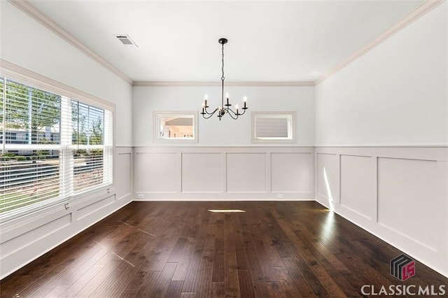 unfurnished dining area featuring ornamental molding, a notable chandelier, and dark hardwood / wood-style flooring