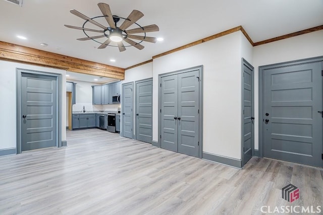 empty room featuring ceiling fan, light wood-type flooring, and wood walls