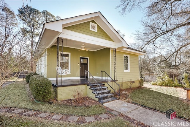 bungalow-style house featuring a front yard, ceiling fan, and covered porch