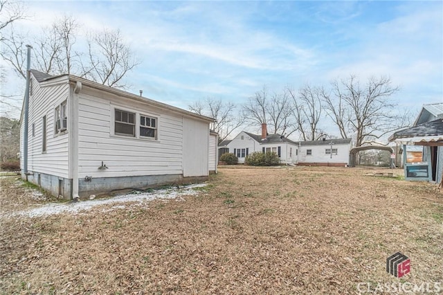 view of side of home with a yard