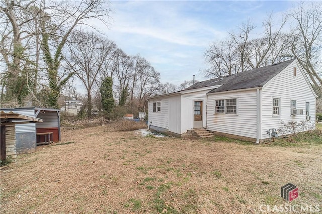 view of side of home featuring cooling unit and a lawn