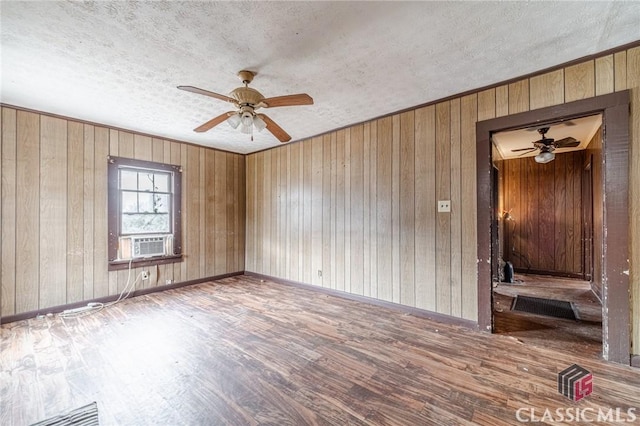 unfurnished room featuring cooling unit, ceiling fan, hardwood / wood-style flooring, and a textured ceiling