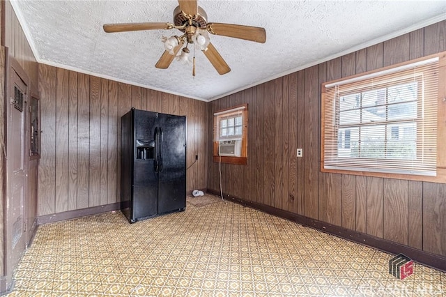 spare room featuring ornamental molding, cooling unit, a textured ceiling, and wood walls