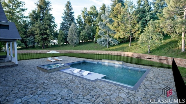 view of pool featuring an in ground hot tub, a yard, and a patio