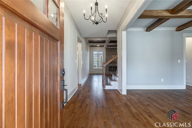 foyer entrance featuring an inviting chandelier, dark hardwood / wood-style floors, and beam ceiling