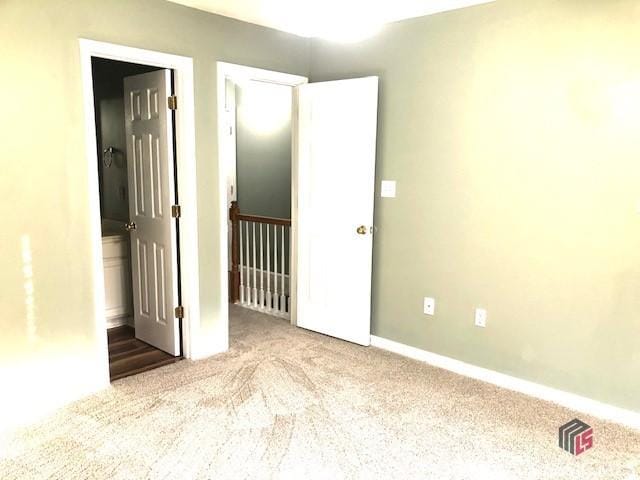 unfurnished bedroom featuring light carpet and ensuite bath