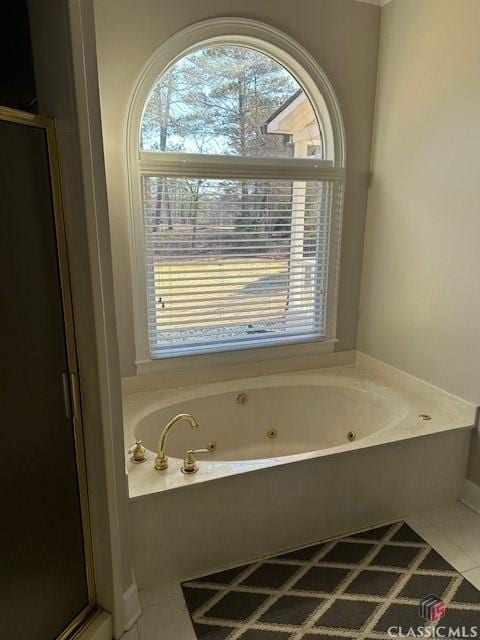 bathroom with tile patterned flooring, shower with separate bathtub, and a healthy amount of sunlight