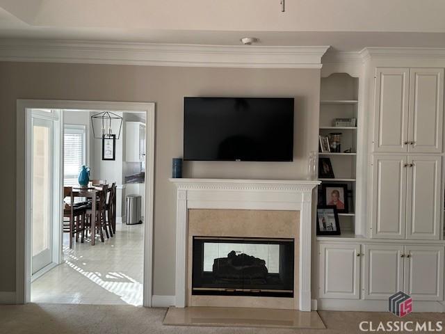 living room featuring a multi sided fireplace and ornamental molding