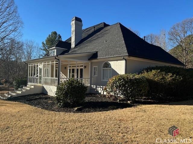 back of house with a yard and a sunroom