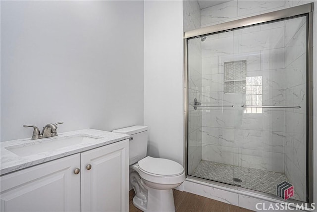 bathroom featuring hardwood / wood-style flooring, vanity, toilet, and an enclosed shower