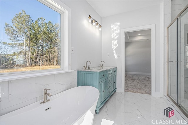 bathroom featuring plenty of natural light, a bathtub, and vanity