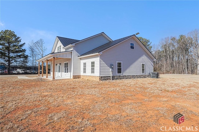 back of property with covered porch and central air condition unit