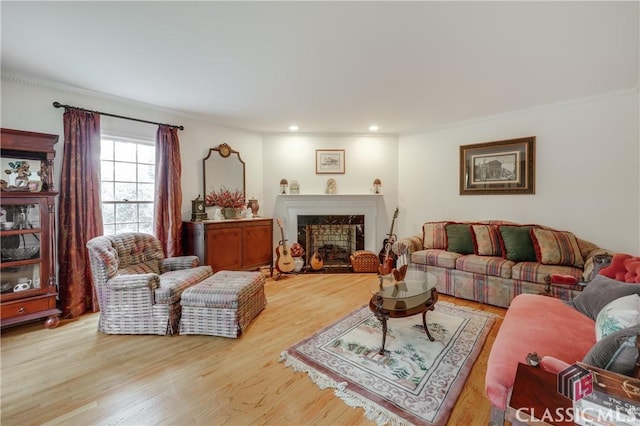 living room with ornamental molding, light hardwood / wood-style floors, and a premium fireplace