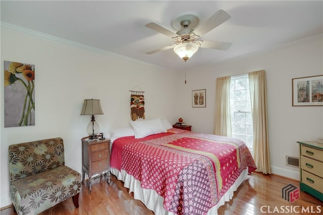 bedroom with crown molding, ceiling fan, and light hardwood / wood-style floors