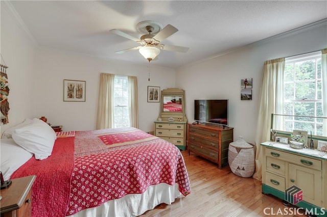 bedroom with crown molding, light hardwood / wood-style floors, and ceiling fan