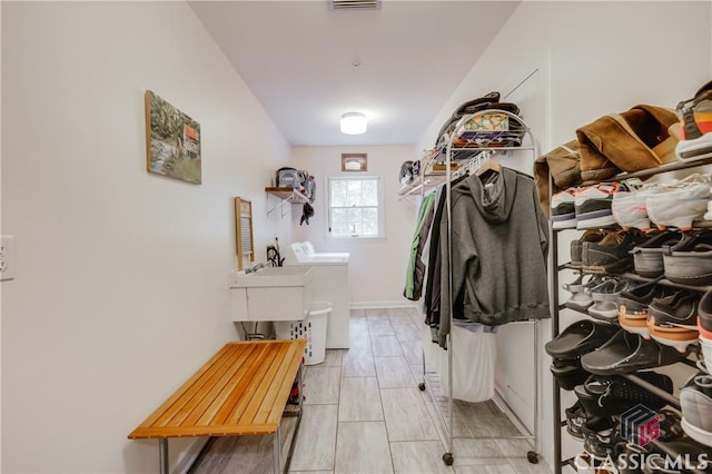 mudroom with separate washer and dryer and sink