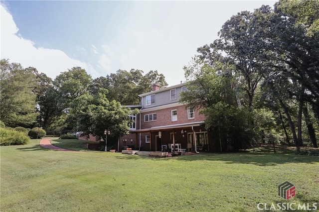 rear view of property featuring a lawn