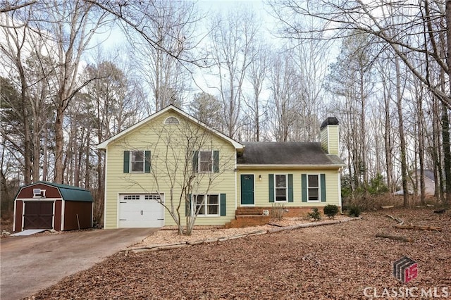 tri-level home with a garage and a shed