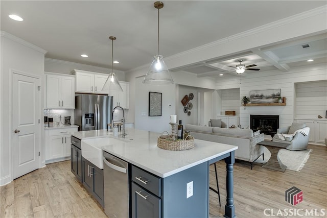 kitchen featuring white cabinetry, stainless steel appliances, coffered ceiling, and beam ceiling