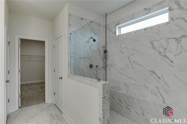 ensuite bathroom with a wealth of natural light, a marble finish shower, and a sink