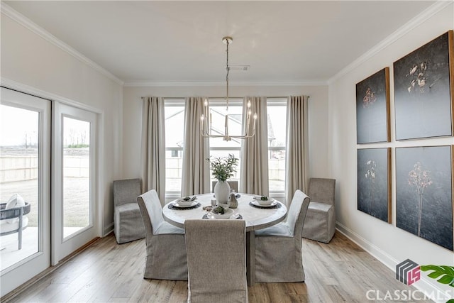 dining area with a notable chandelier, light hardwood / wood-style flooring, and a wealth of natural light