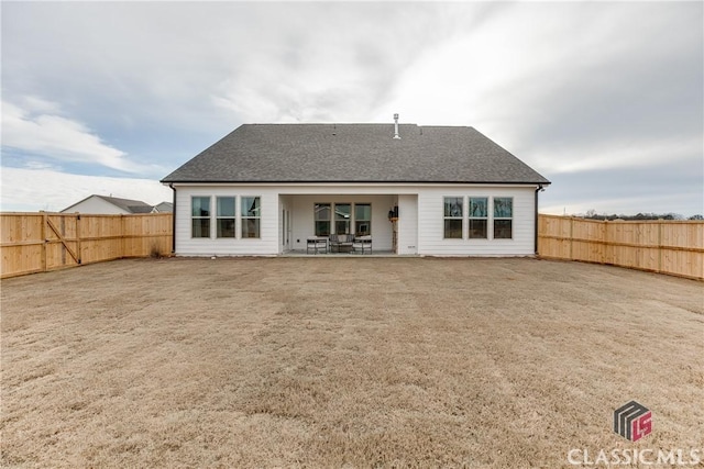 back of property with a lawn and a patio area