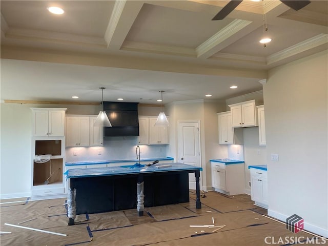 kitchen featuring crown molding, white cabinetry, and a kitchen island with sink