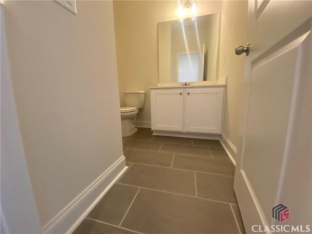 226 Montview Dr, Jefferson, GA 30549 - half bathroom featuring tile patterned flooring, toilet, vanity, and baseboards