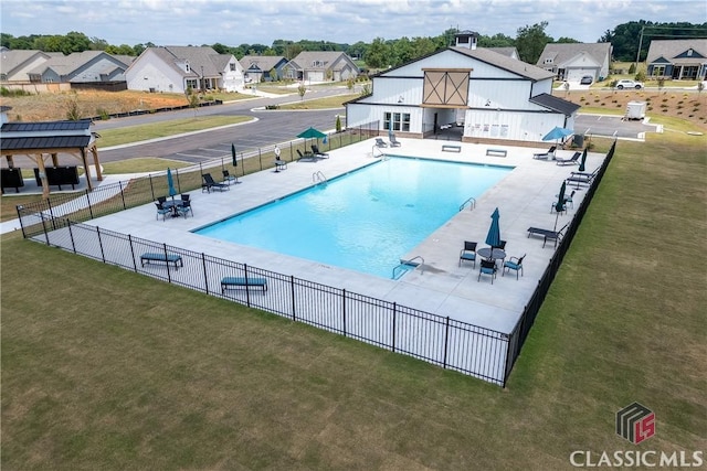 view of tennis court with a residential view and fence