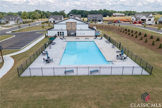 view of tennis court featuring fence and a residential view