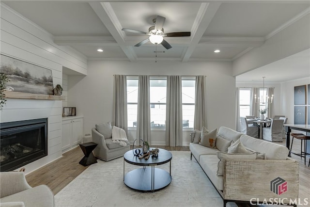 living room with coffered ceiling, crown molding, light hardwood / wood-style floors, and beamed ceiling