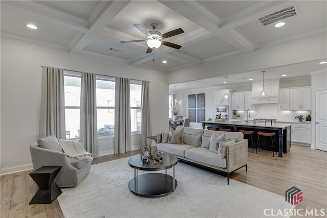 living room with coffered ceiling, beam ceiling, and light hardwood / wood-style floors