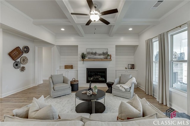 living room with coffered ceiling, crown molding, a large fireplace, and beamed ceiling