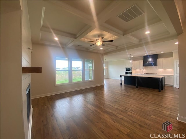 226 Montview Dr, Jefferson, GA 30549 - unfurnished living room featuring a ceiling fan, dark wood-type flooring, a large fireplace, beamed ceiling, and baseboards