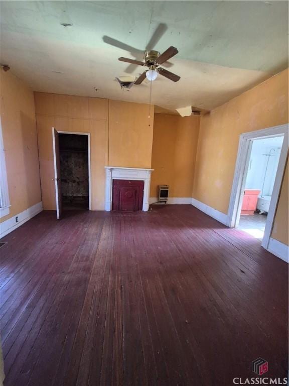 unfurnished living room featuring dark wood-type flooring and ceiling fan