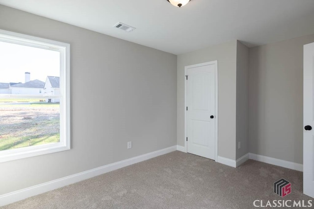 unfurnished bedroom featuring multiple windows and carpet