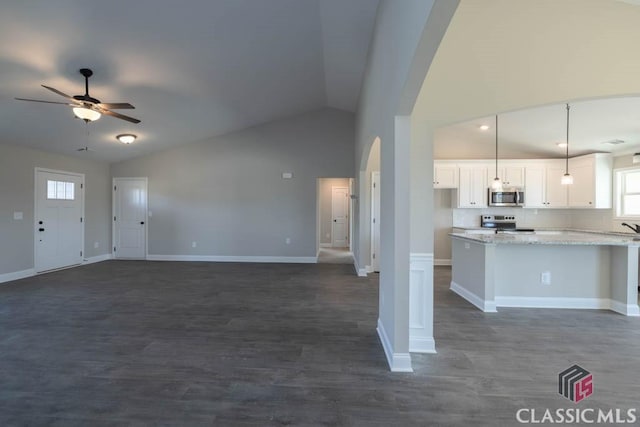 unfurnished living room with high vaulted ceiling, dark hardwood / wood-style floors, and ceiling fan