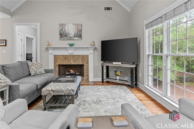1750 Ryland Hills Dr, Watkinsville, GA 30677 - living area featuring a tiled fireplace, visible vents, vaulted ceiling, and wood finished floors