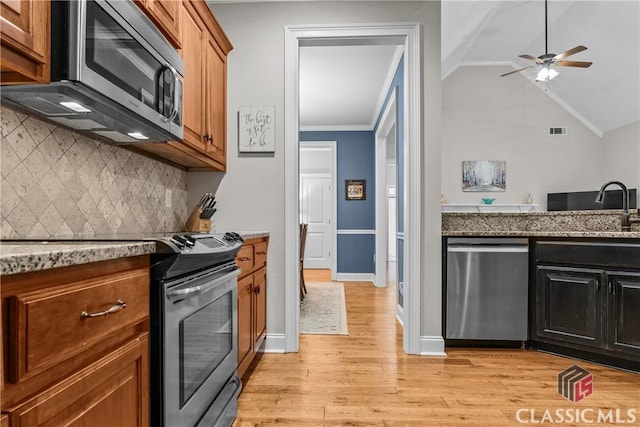 1750 Ryland Hills Dr, Watkinsville, GA 30677 - kitchen featuring visible vents, vaulted ceiling, appliances with stainless steel finishes, a sink, and light wood finished floors