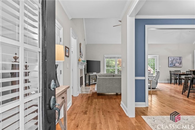 foyer with ornamental molding and light hardwood / wood-style floors